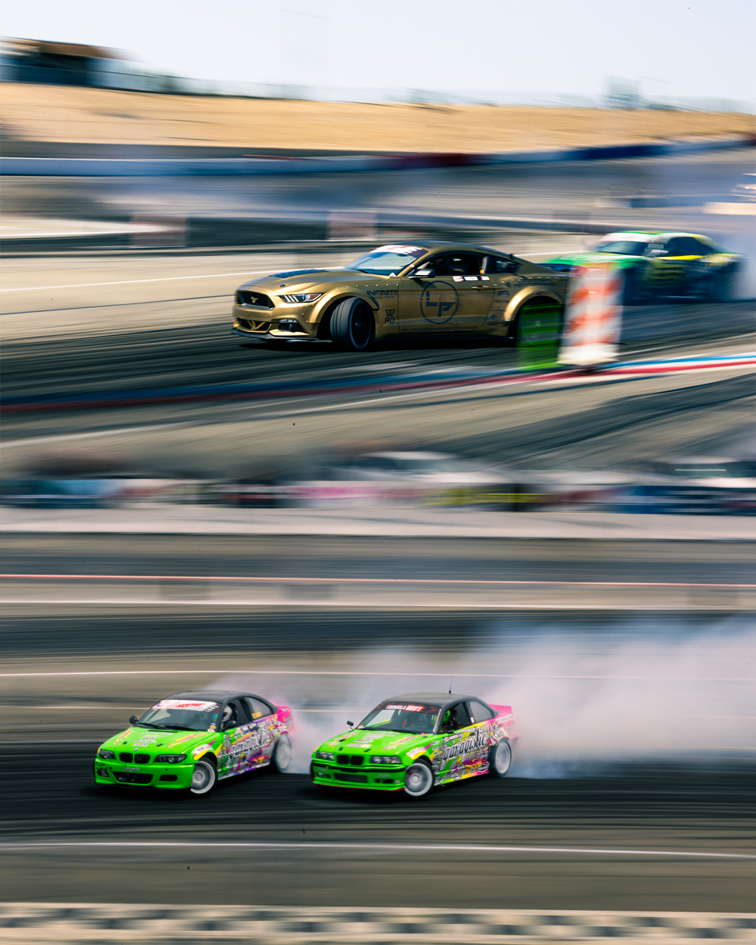 A blended image of two sets of cars tandem drifting.